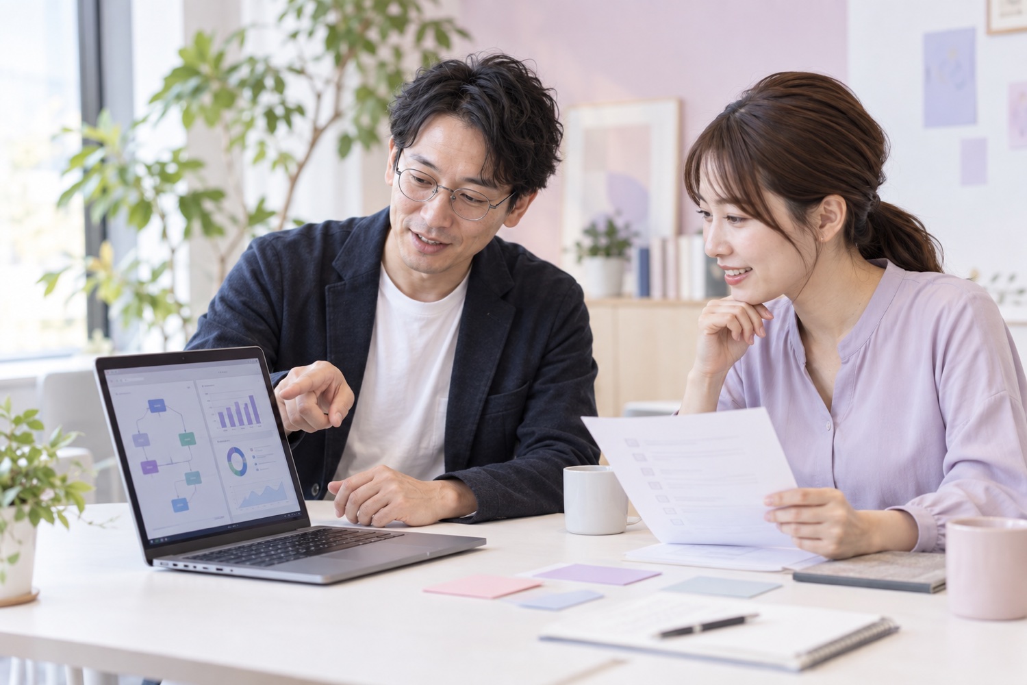 担当者と支援者がパソコンの試作画面と確認項目を見ながら導入を進める様子